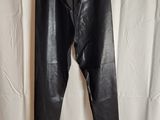 un pantalon en cuir noir suspendu à un cintre