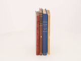 three books stacked on top of each other on a white surface