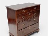 a wooden chest of drawers with brass handles and drawers