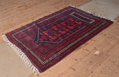 un tapis rouge et noir posé sur le sol d'une pièce