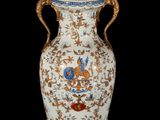 a large vase with a bird on it on a stand
