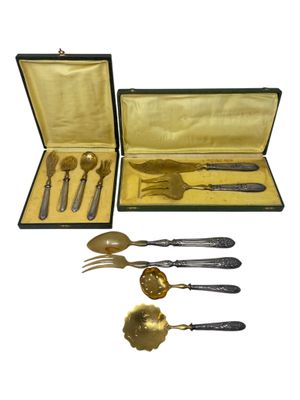 a set of silverware in a case on a white background