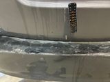 a rusted bumper on the back of a car
