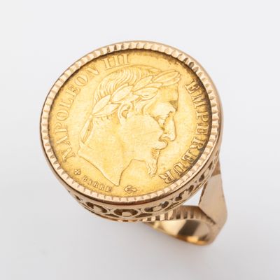 une image représentant une bague en forme de pièce d'or sur laquelle est gravé le visage d'une femme