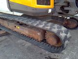 a yellow and black excavator that is parked outside of a building