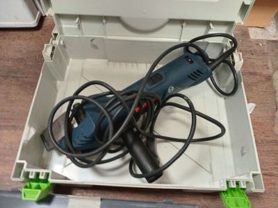 une boîte contenant une perceuse et une cordelette