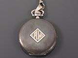 an antique silver pocket watch with a chain hanging from it ' s side