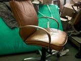 a brown leather office chair in a room full of boxes