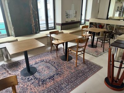 des tables et des chaises dans une pièce où il y a un tapis au sol