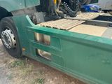 a green truck with a flat bed on the back of it