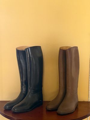 une paire de bottes de pluie noires et marron posée sur une table en bois