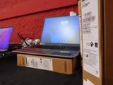 two laptops that are sitting on a table in front of a red wall