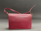 a red leather shoulder bag on a grey background