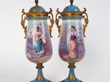une paire de vases ornés de personnages peints, posés sur une table