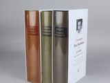 three books are stacked on top of each other on a table