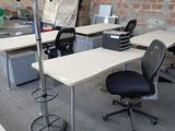 plusieurs bureaux et chaises dans une pièce aux murs en briques