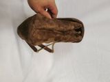 someone is holding a brown purse with a chain around it