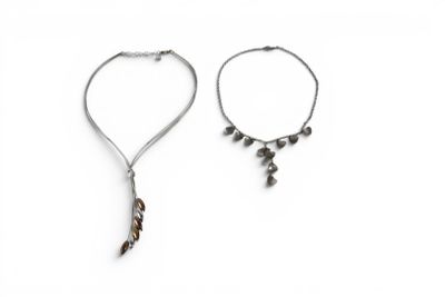 two necklaces and a bracelet with a feather on a white background