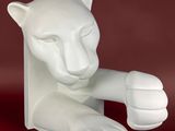 une sculpture blanche représentant un chat assis sur une surface rouge