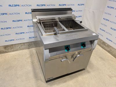 a silver fryer sitting on top of a counter next to a wall