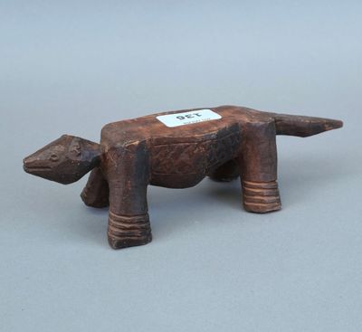 une vieille figurine d'animal en bois avec une étiquette autour du cou