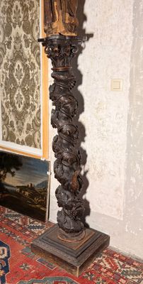 une haute colonne en bois surmontée d'une statue