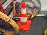 orange and white cone sitting on the floor next to a fire hydrant