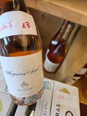 a bottle of wine sitting on a table next to a bottle of wine