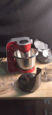 un mixeur rouge posé sur une table en bois