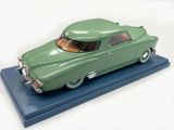 a green toy car that is on a blue platform