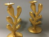 pair of gold leaf candlesticks on a white background