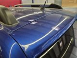 a close up of a blue car in a garage