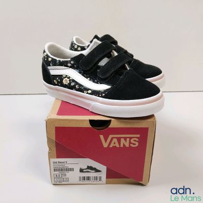 Des baskets Vans Old Skool dans une boîte posée sur une surface blanche