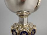 a silver goblet with blue and gold decorations on it