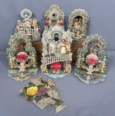 cinq figurines représentant des personnes dans un jardin, ornées de fleurs