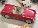a red toy car sitting on a table next to other toy cars
