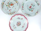 trois assiettes à motifs floraux posées sur une surface blanche