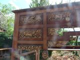 a wooden door with carvings on it in a garden