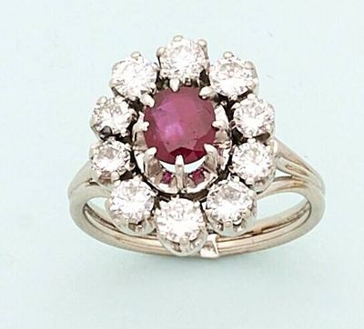 a close up of a ring with a pink stone surrounded by white diamonds