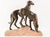 statue of two greyhounds on a rock on a white background