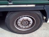 a close up of a flat tire on a green truck