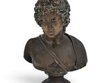 an old bronze bust of a man with curly hair on a white background