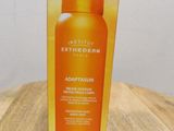 an orange bottle of sun lotion sitting on top of a wooden table