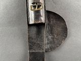 ceinture en cuir avec une boucle métallique sur un fond gris