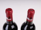 two bottles of wine sitting next to each other on a table