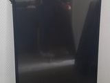 un téléviseur noir posé sur un parquet dans une pièce