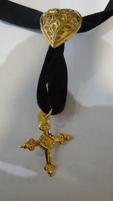 un collier orné d'un cœur et d'une croix en or
