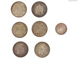 une image représentant un ensemble de pièces de monnaie sur lesquelles figurent les portraits d'un homme et d'une femme