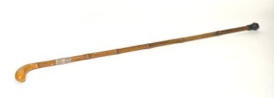 une vieille crosse de hockey avec un manche en bois posée sur une surface blanche