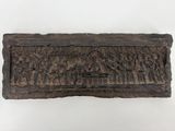 un gros plan d'une plaque en bois ornée de sculptures